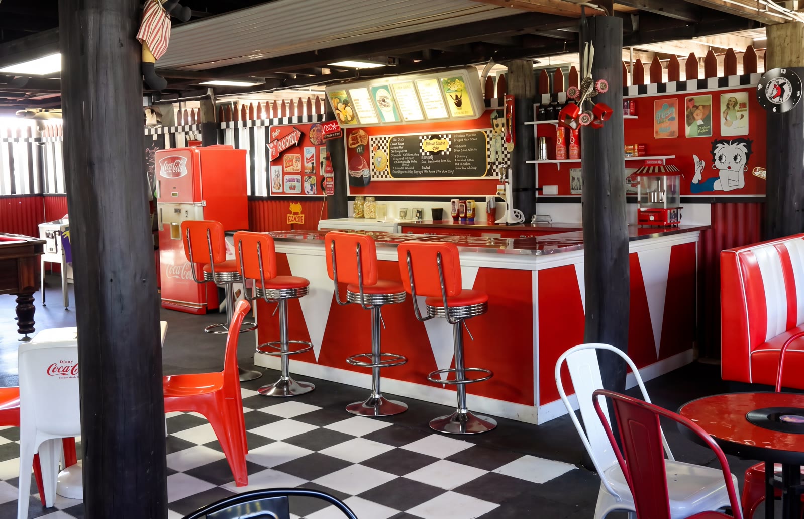 Retro Coca-Cola themed diner with red chairs and chequered floor