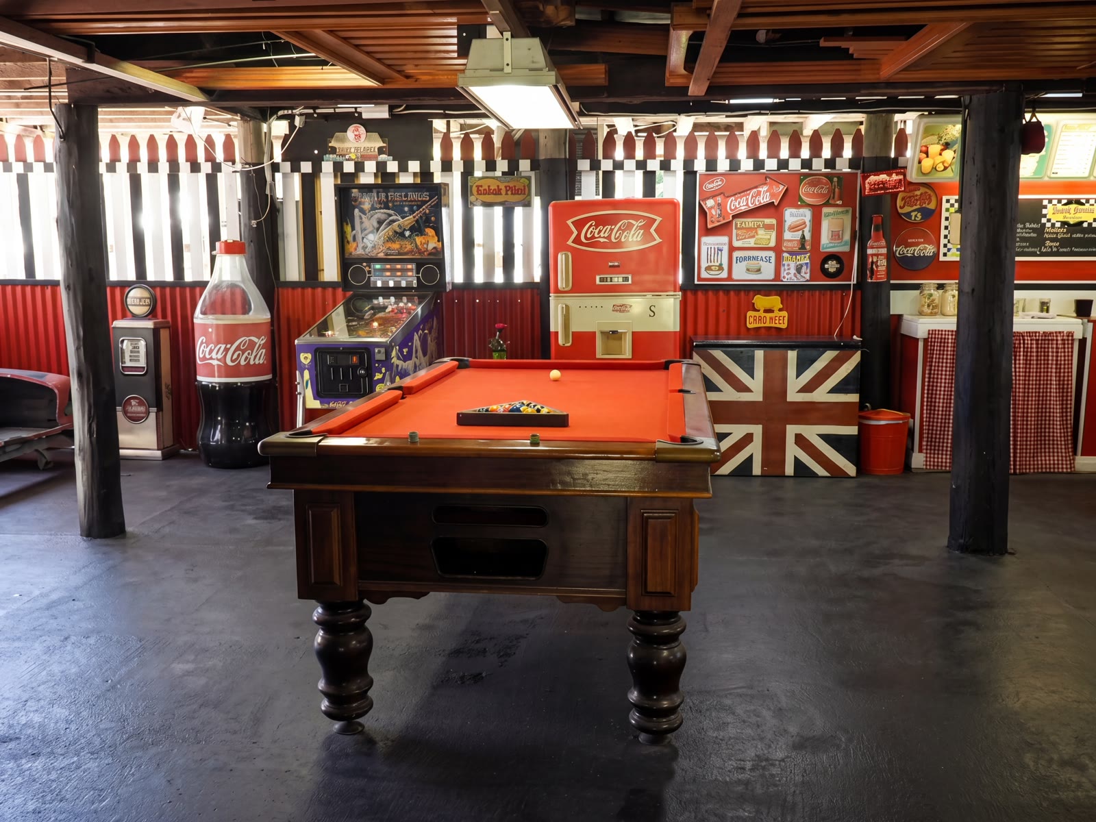 Retro games room with a red-felt pool table and pinball machine