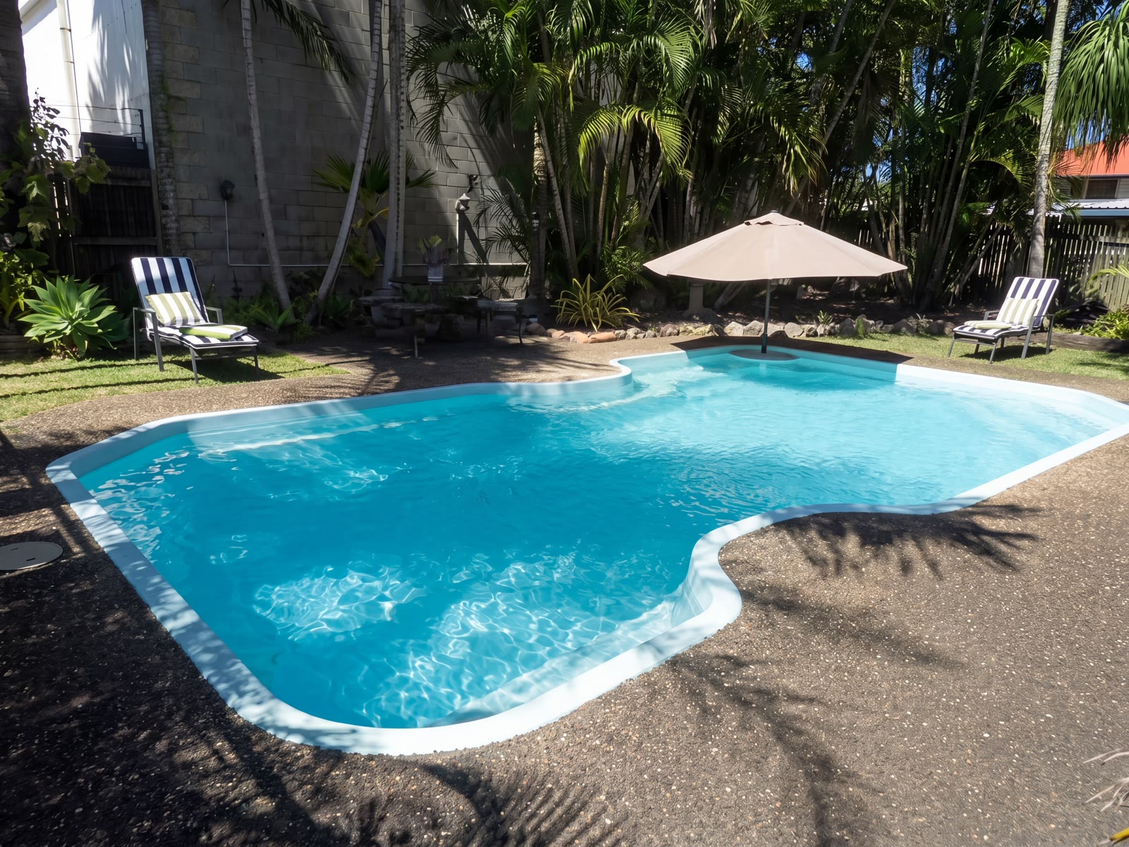 Sparkling outdoor swimming pool surrounded by tropical garden